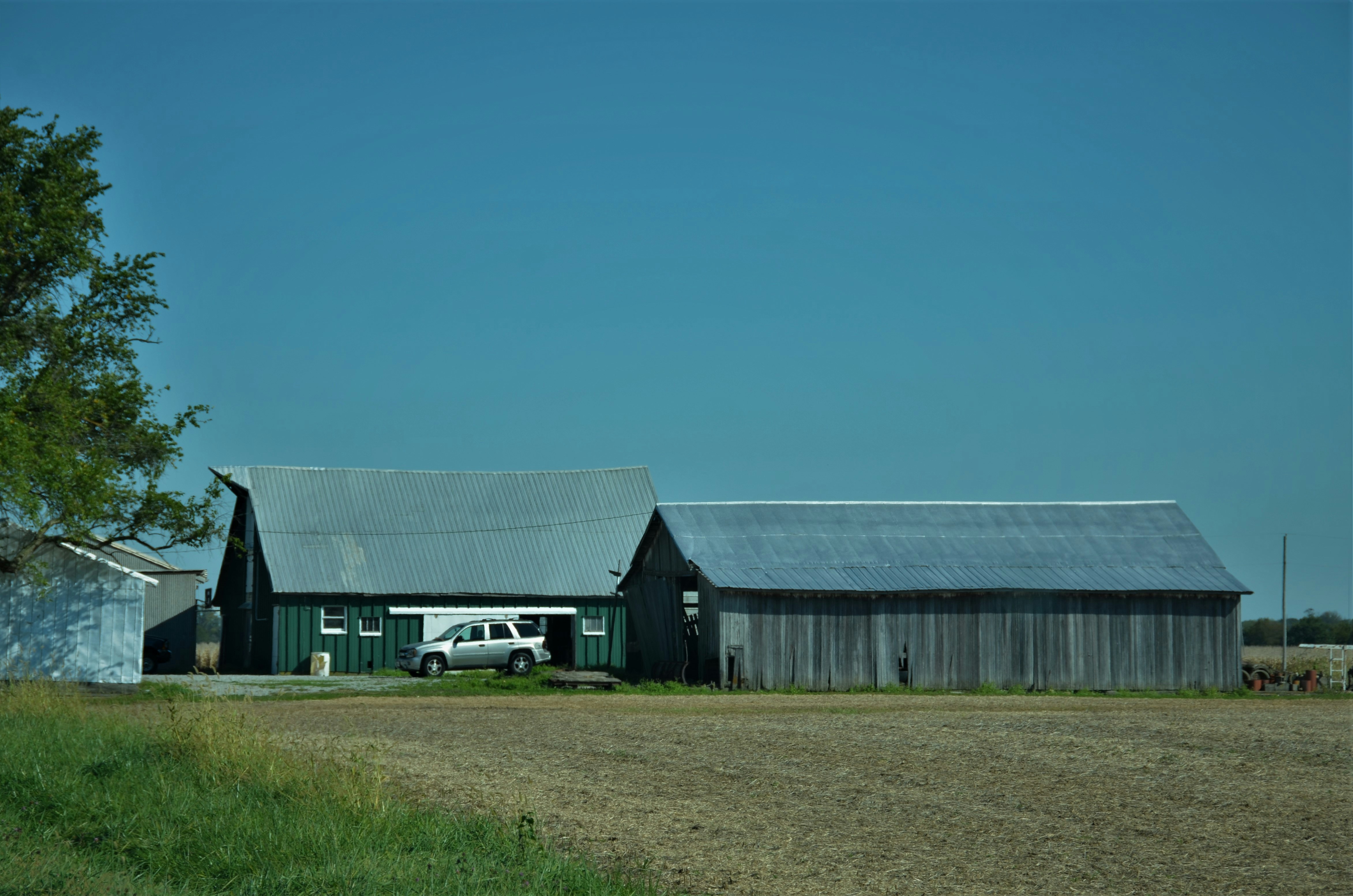 a truck parked in front of a barn, Faded old barns