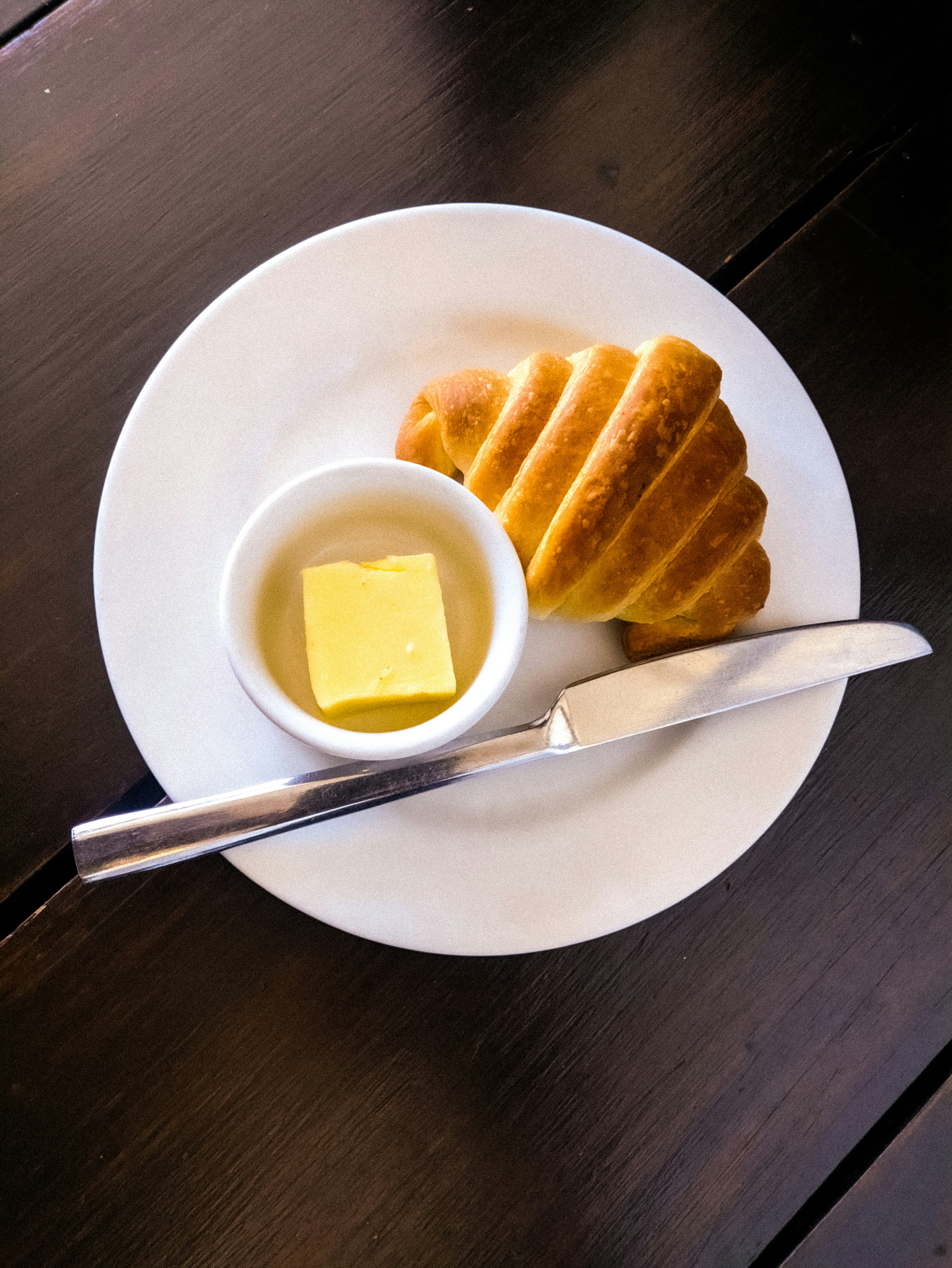 Golden butter croissant on white surface