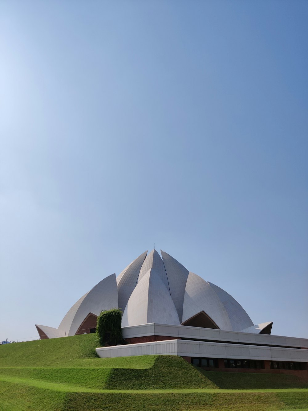 a large white building sitting on top of a lush green field