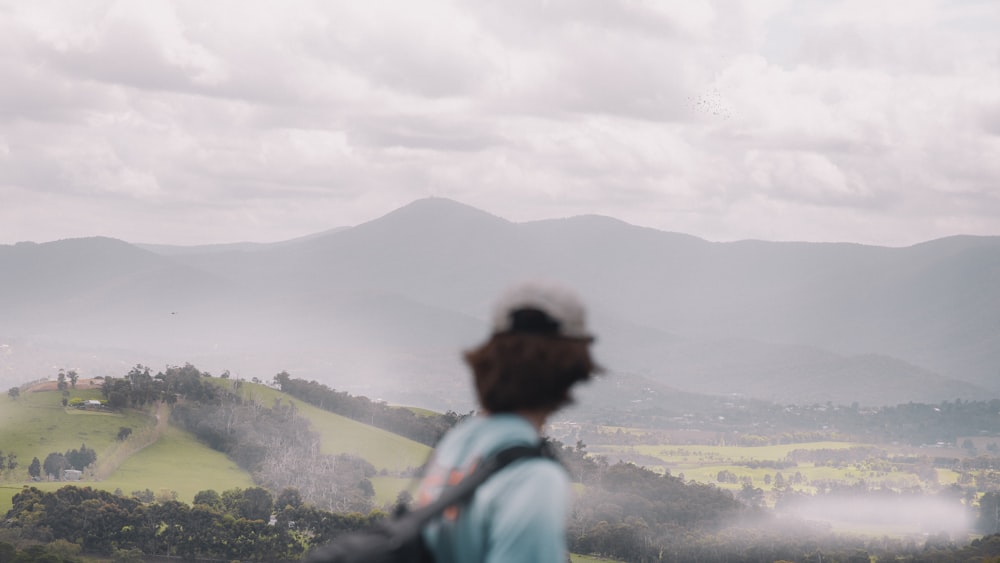 a man standing on top of a lush green hillside