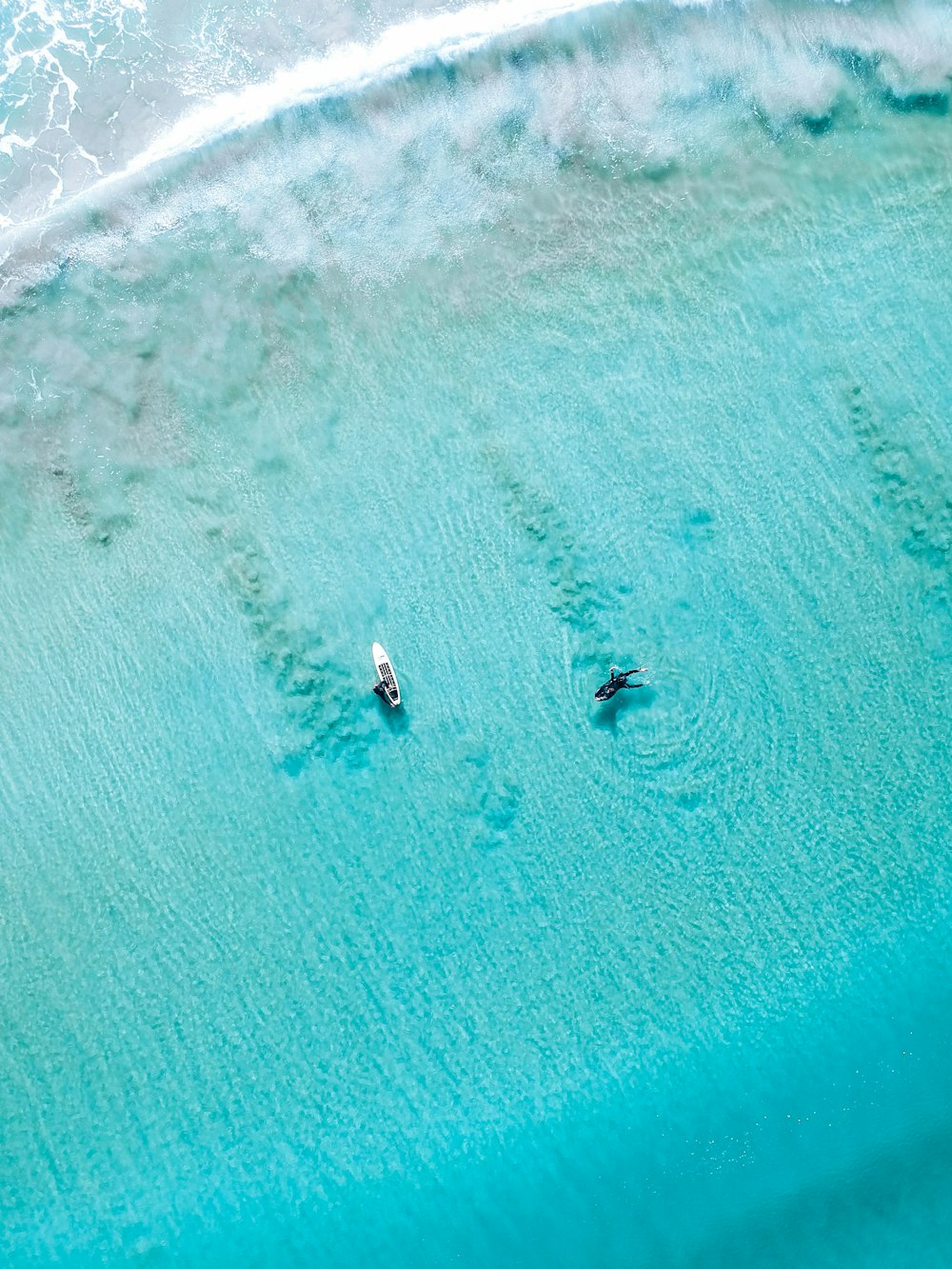 two surfers in the ocean with their surfboards