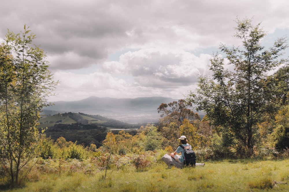 a person sitting on a bench in a field