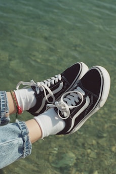 a person's feet in a pair of black and white sneakers