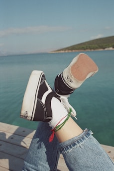 a person's legs with black and white shoes