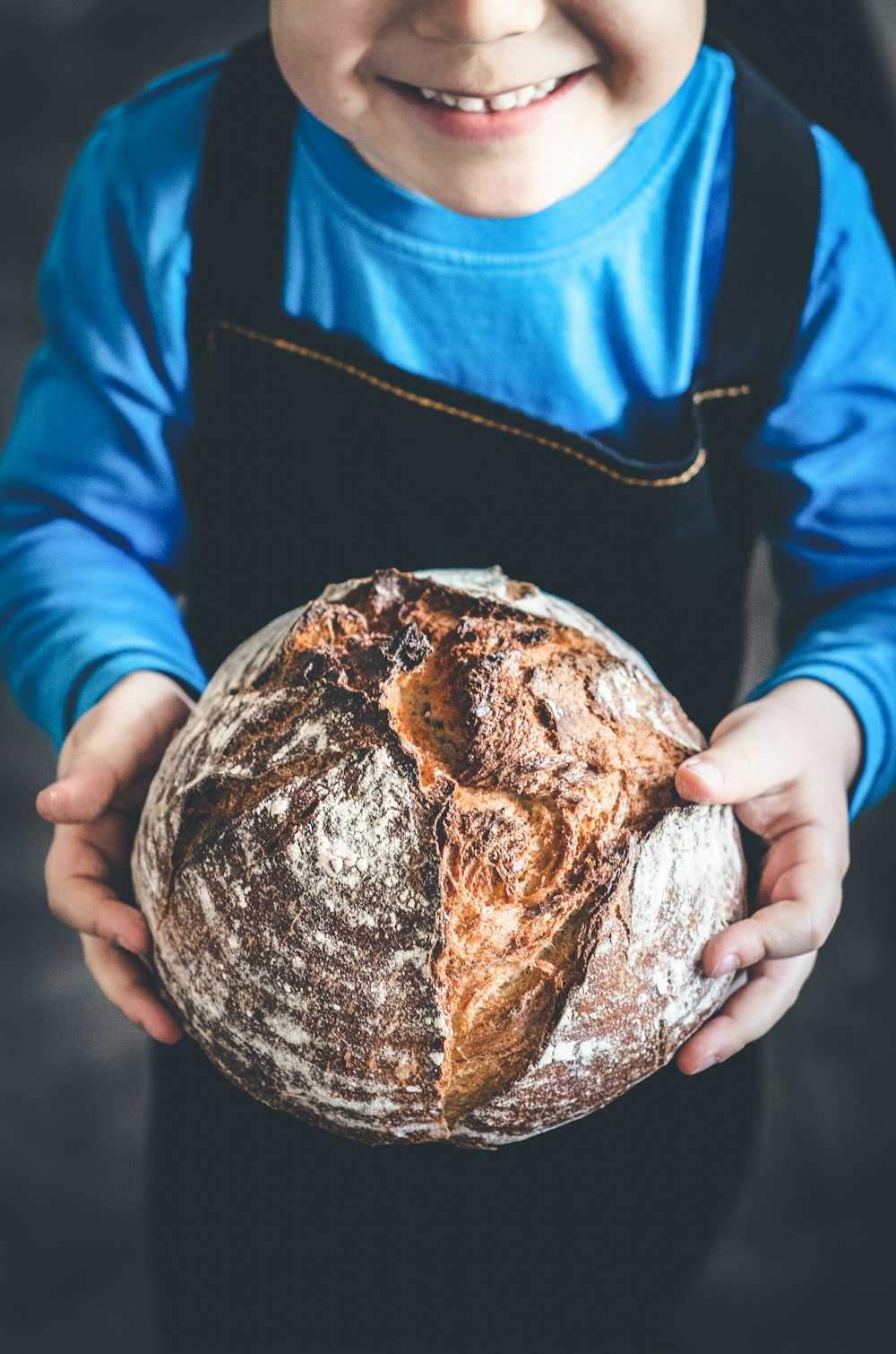 a young boy holding a loaf of bread