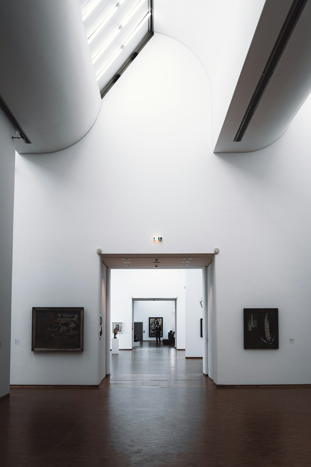 a large white room with paintings on the walls