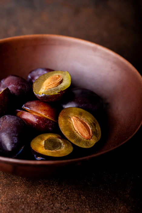 Close-up of vibrant fruit pulp in a rustic wooden bowl with fresh fruits around
