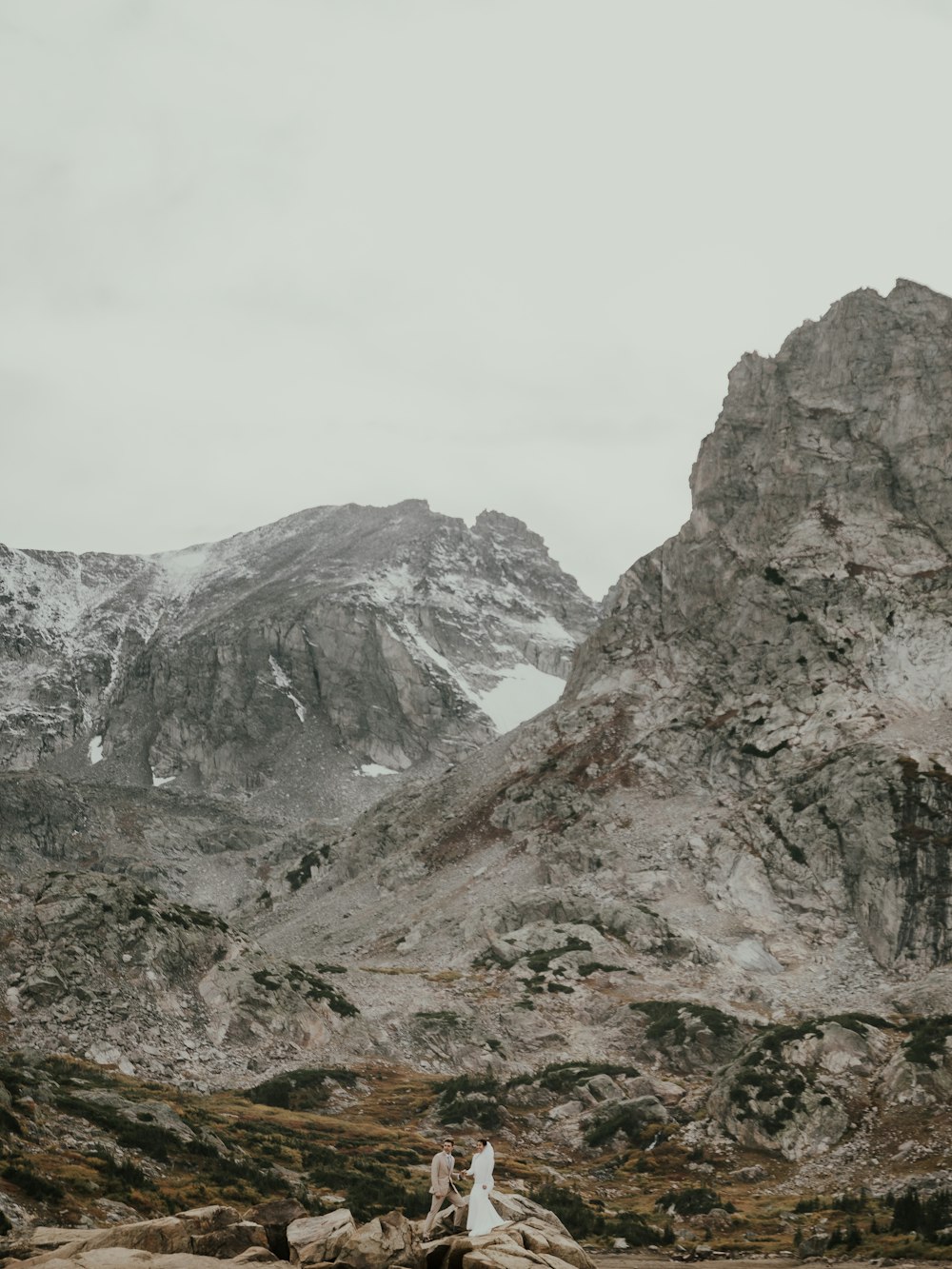 a couple of people standing on top of a mountain