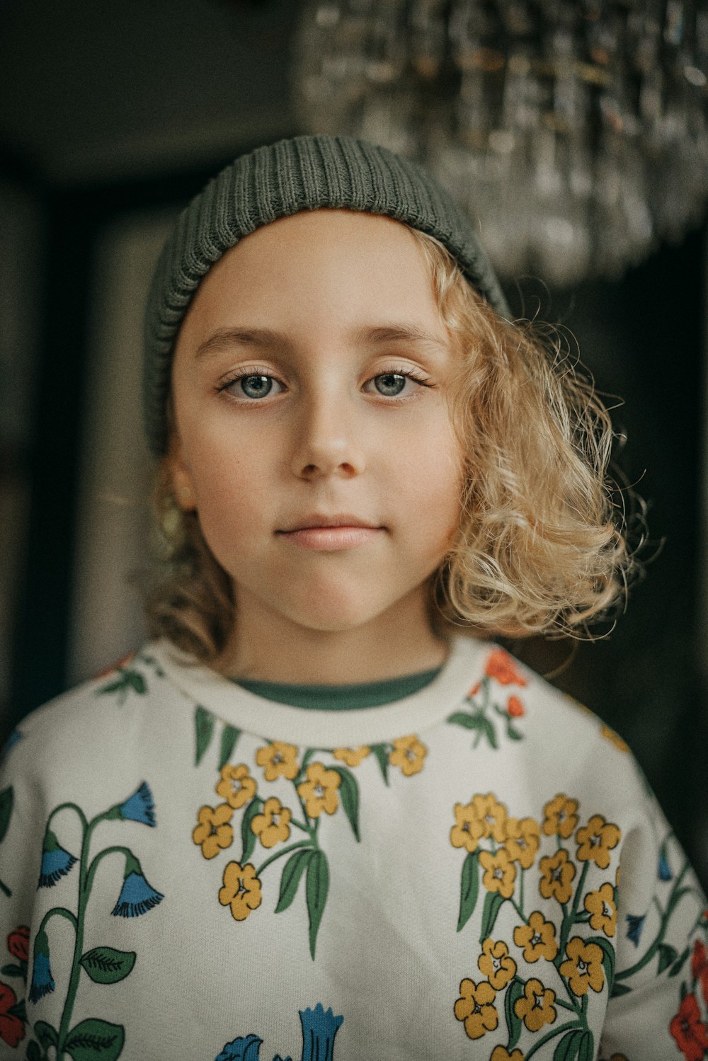 a little girl with blonde hair wearing a hat