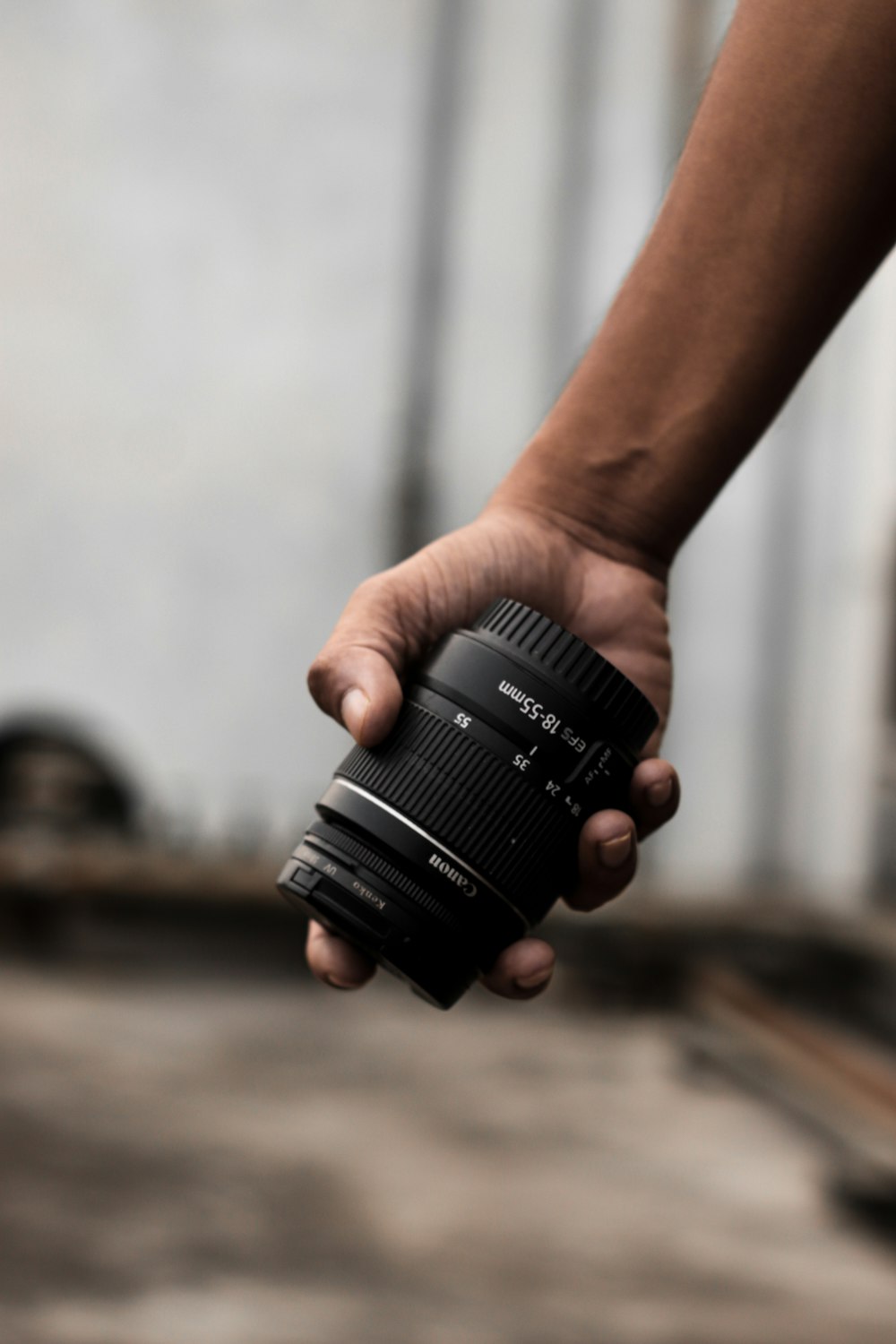 a person holding a camera lens in their hand