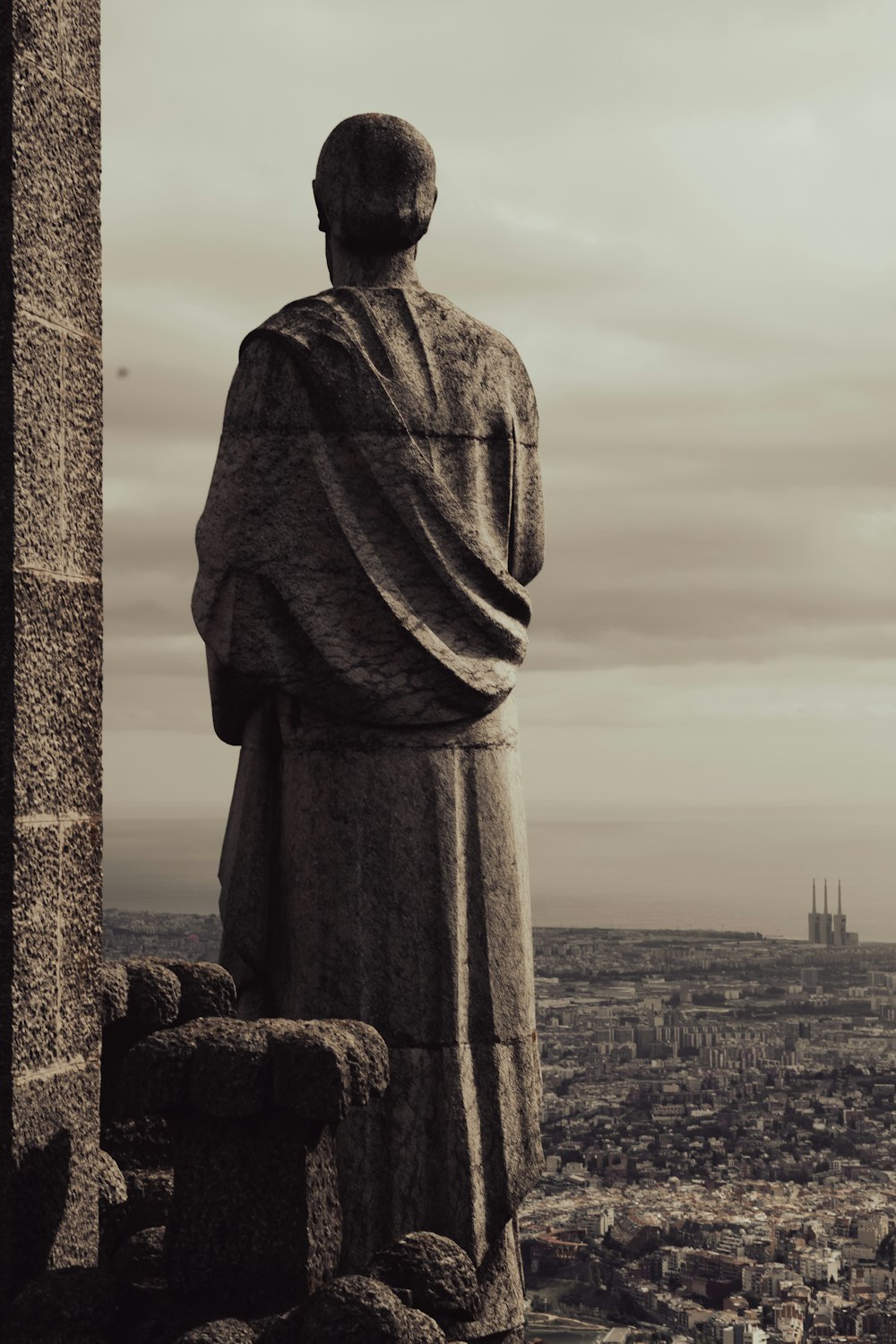 a statue of a monk overlooking a city