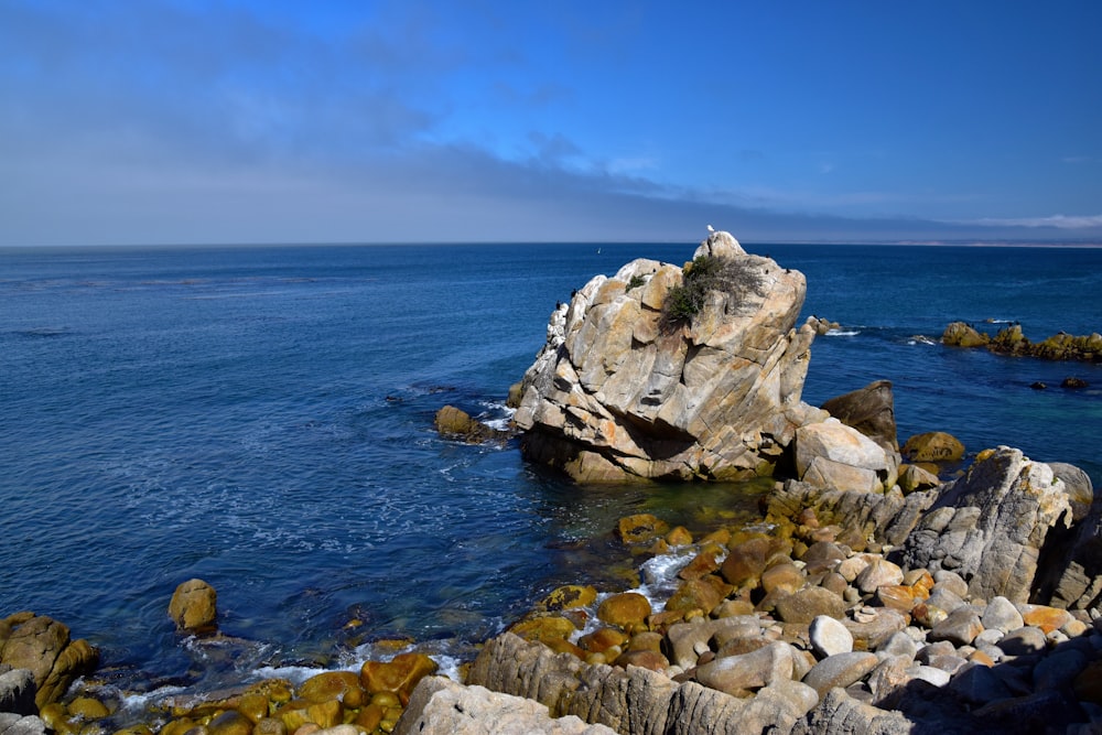 a large rock outcropping in the middle of a body of water