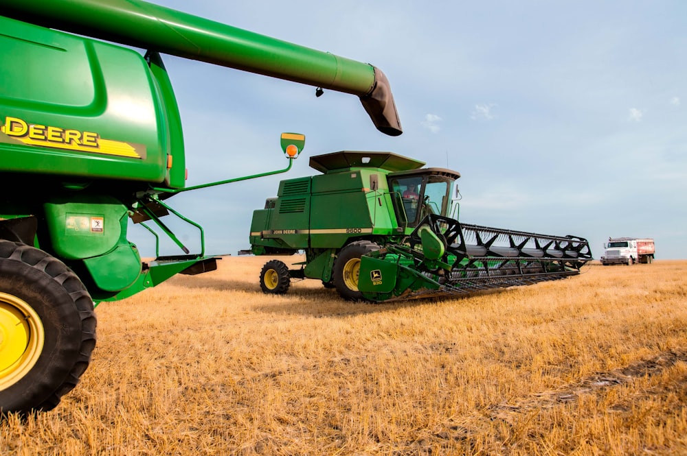 a large green tractor in a field of brown grass