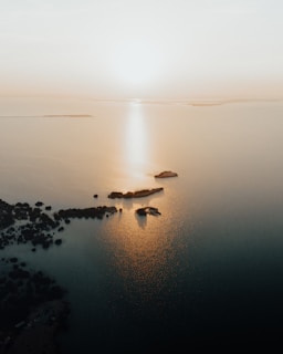 A panoramic view of the Surin Islands coastline at sunrise, with golden light touching the waves.