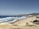 A scenic view of the coastline with people enjoying the beach.