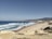 A scenic view of the coastline with people enjoying the beach.