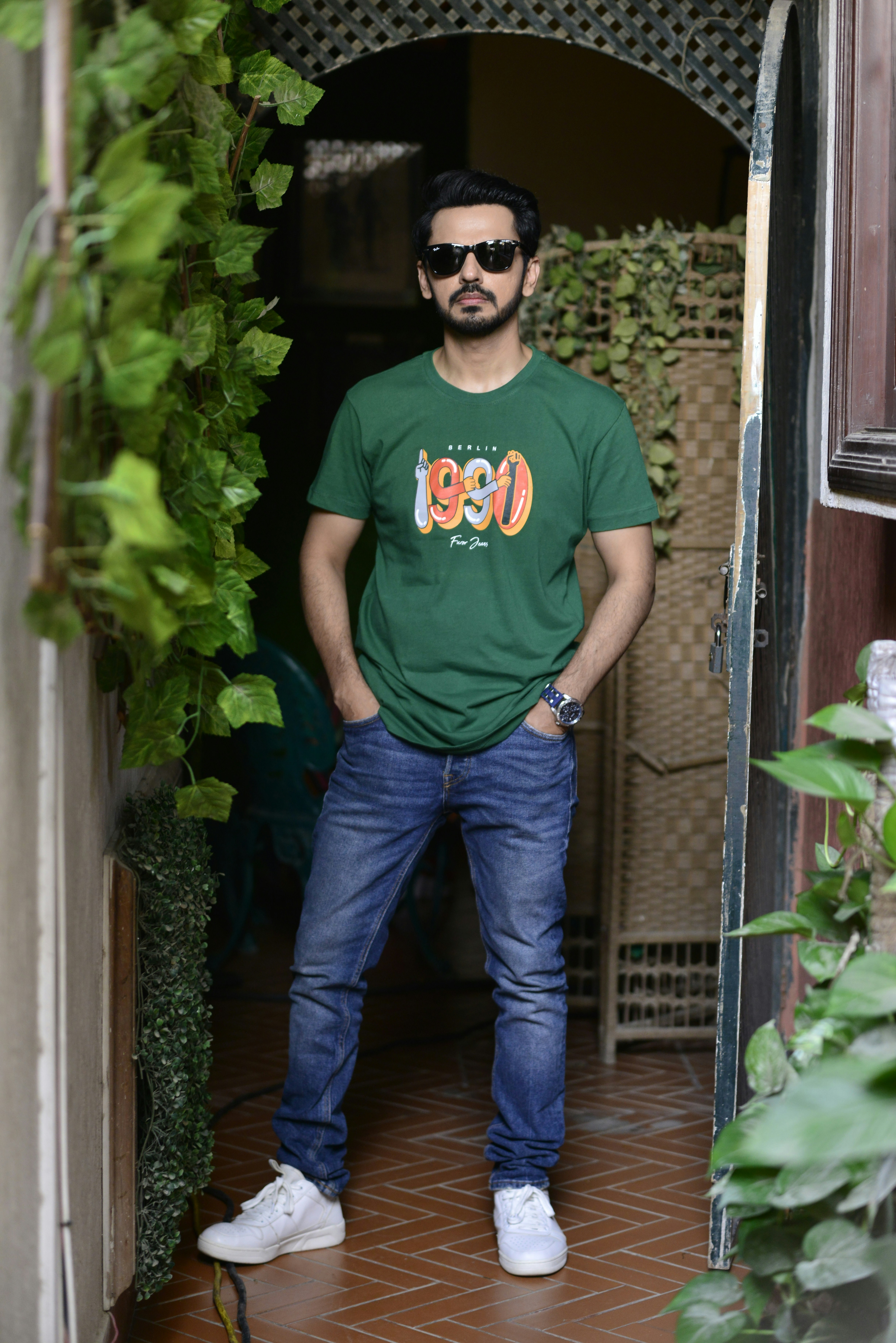 a man standing in a doorway with his hands in his pockets