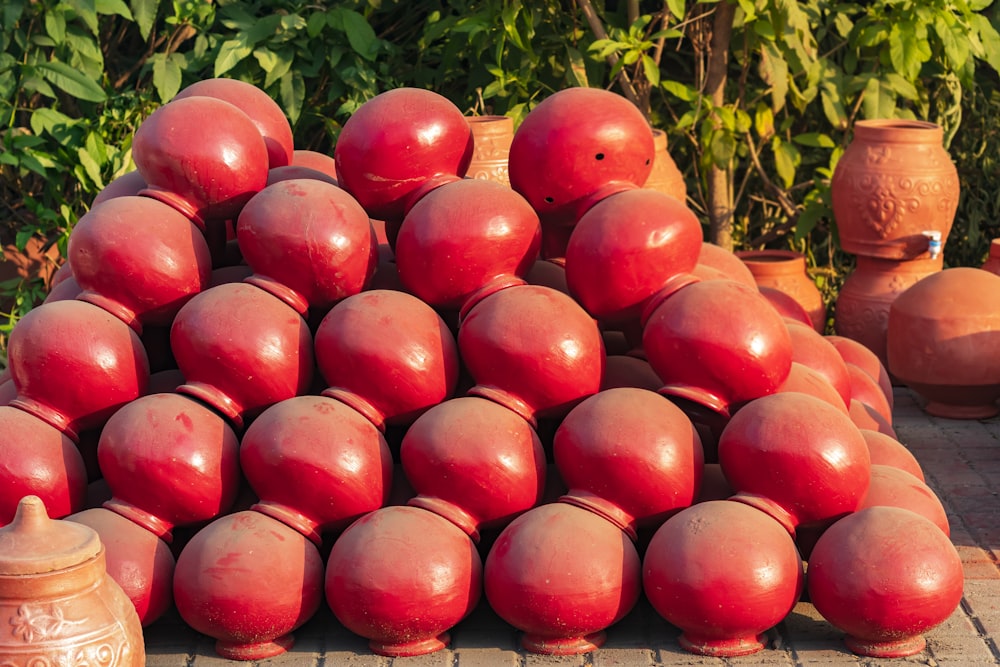 a pile of red fruit sitting on top of a sidewalk