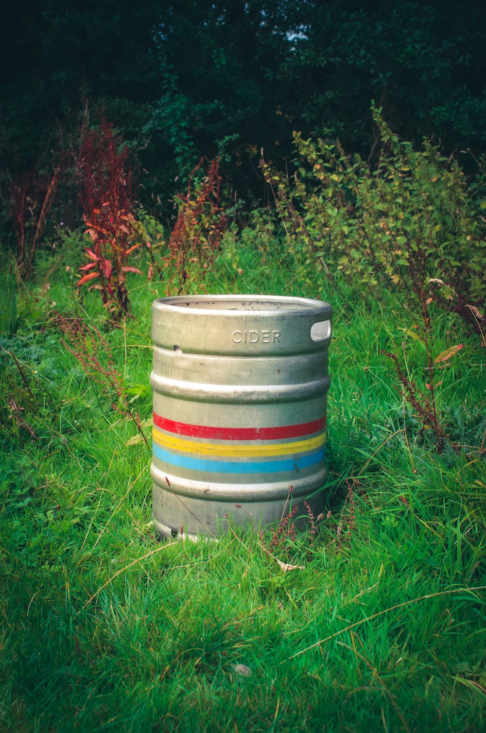 a large metal barrel sitting in the middle of a field