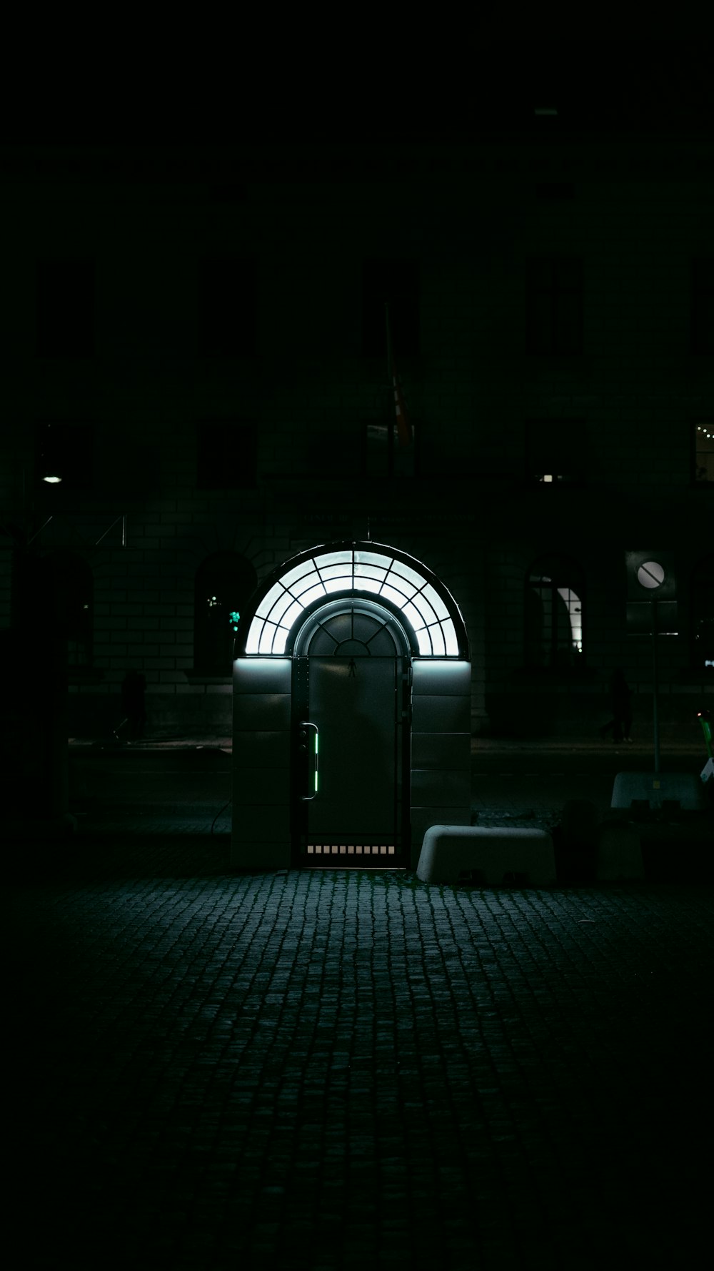 a dark room with a door and a bench