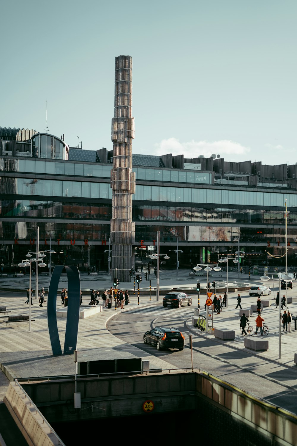 a group of people walking across a street next to a tall building