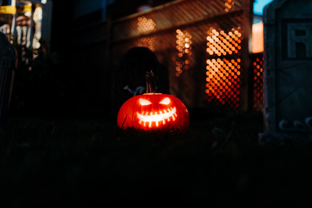 a carved jack o lantern sits in front of a house