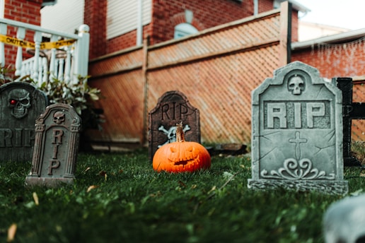 a cemetery with tombstones and a pumpkin in the grass