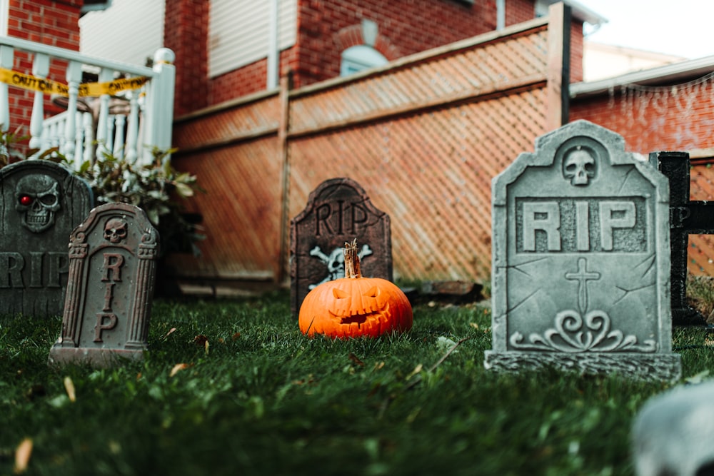 a cemetery with tombstones and a pumpkin in the grass