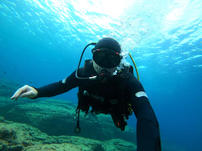 a man in a diving suit is holding out his hand