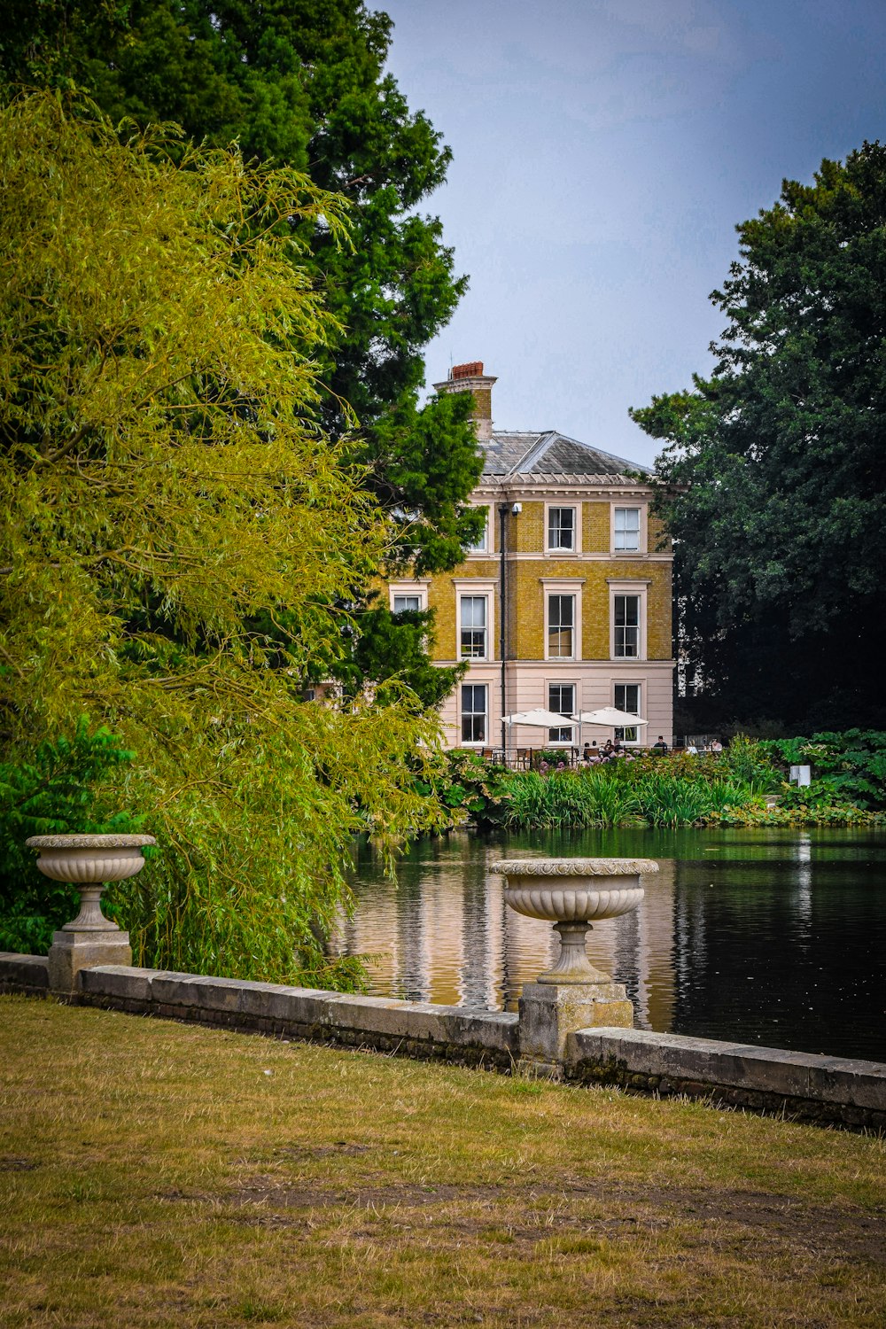 a large yellow house sitting next to a body of water