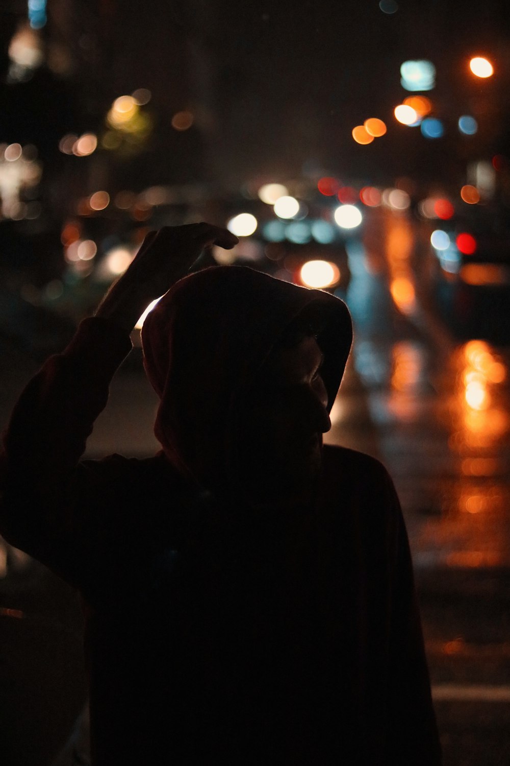 una persona parada en una calle por la noche