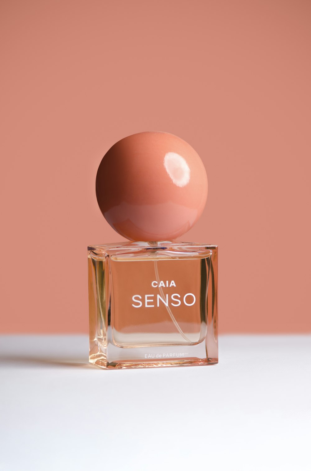 an egg sitting on top of a bottle of perfume