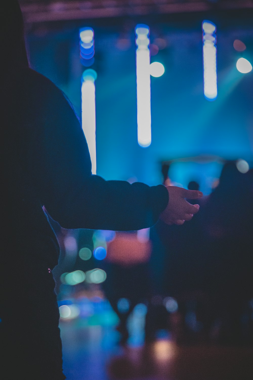 two people shaking hands in front of a stage