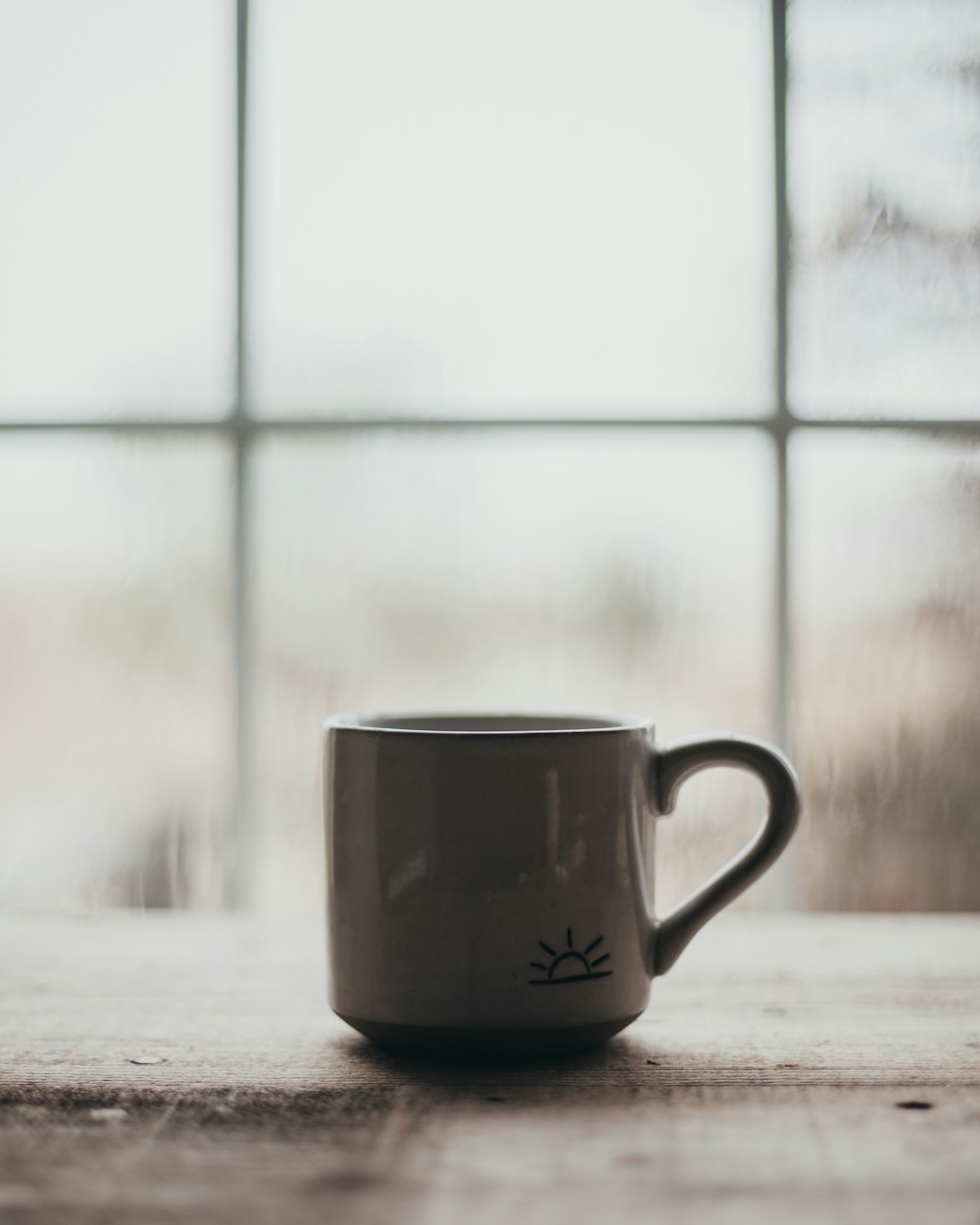 a white coffee cup sitting on top of a wooden table