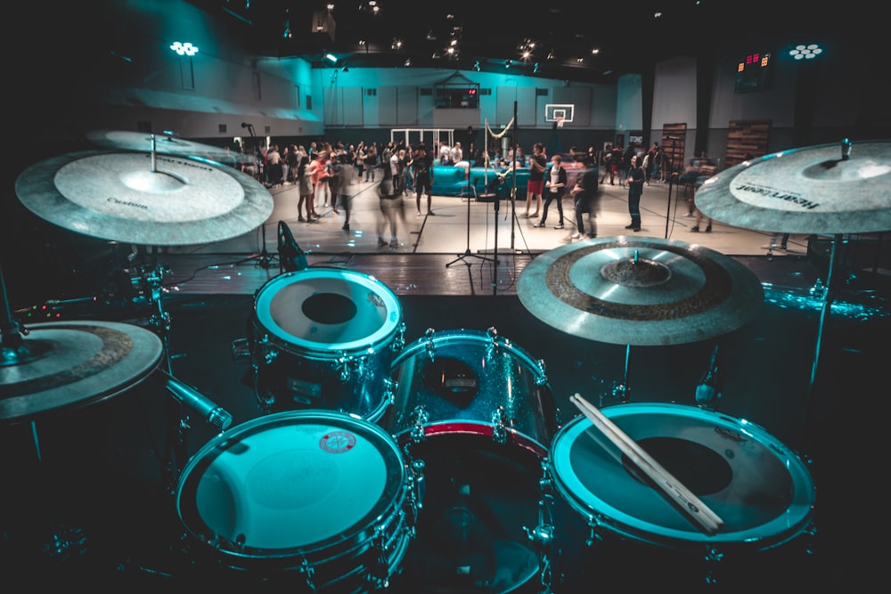 a group of people standing around a drum set