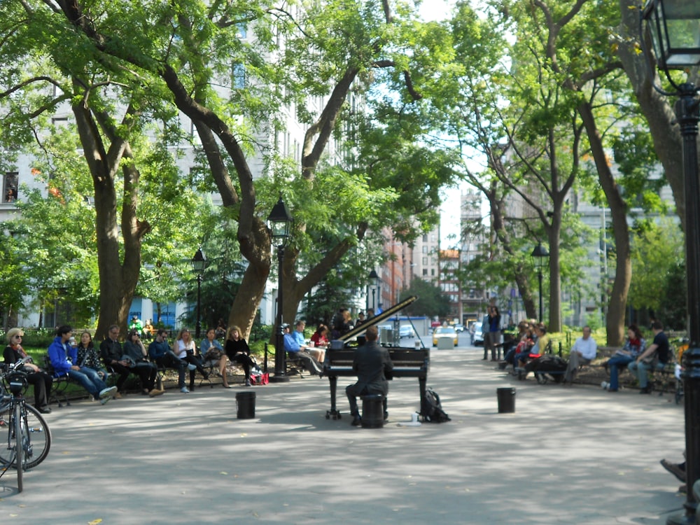 a man playing a piano in the middle of a park