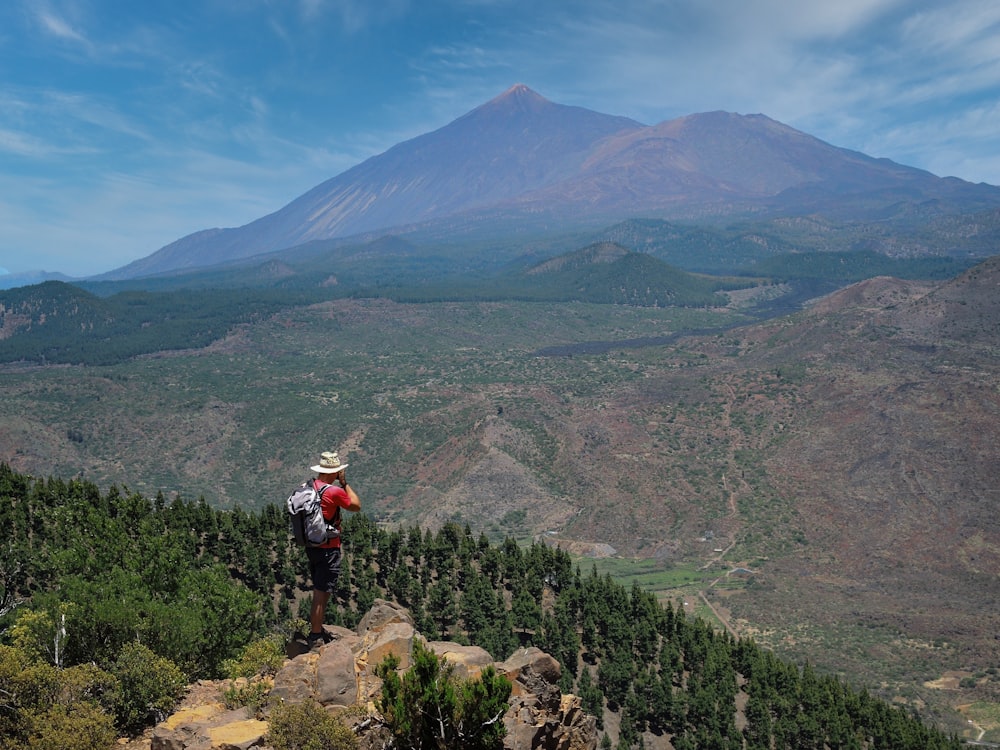 a man standing on top of a lush green hillside