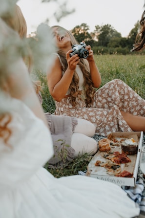 A candid shot of friends sharing a picnic on a green lawn.
