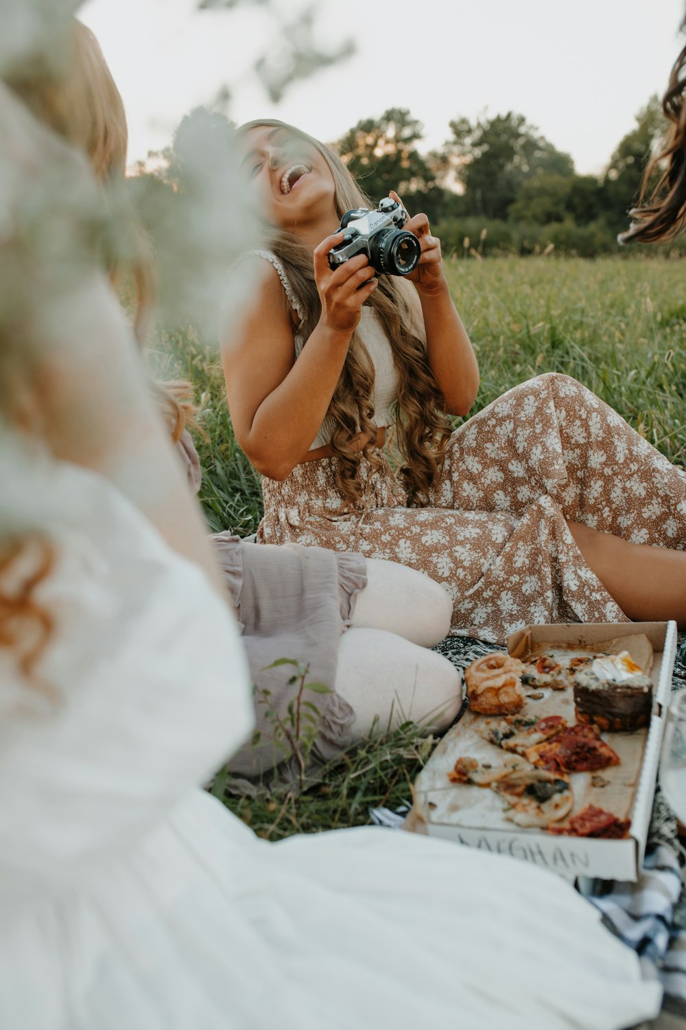 a woman sitting on the ground taking a picture of herself