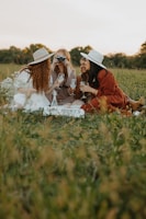 A group of diverse women enjoying a picnic in stylish dresses.