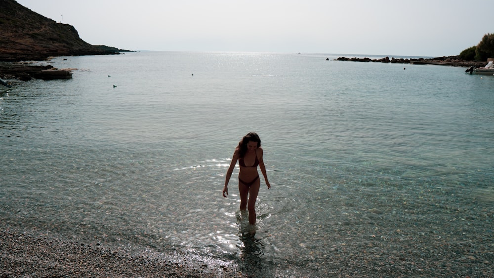 a woman wading in the water at the beach