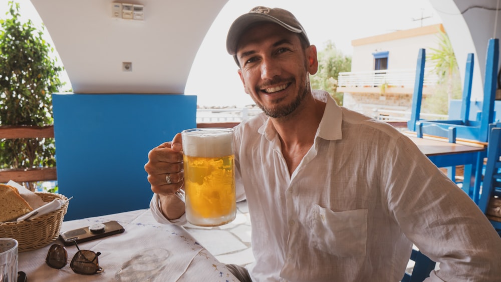 a man sitting at a table with a glass of beer
