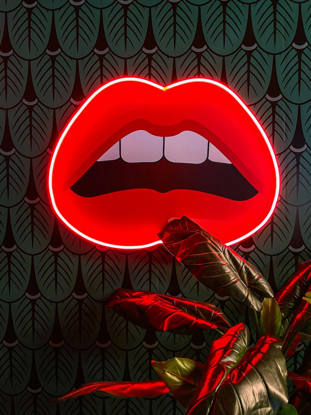 a red neon sign with a large open mouth