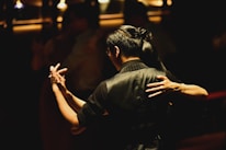 Close-up of a camera lens focusing on a dancing couple.