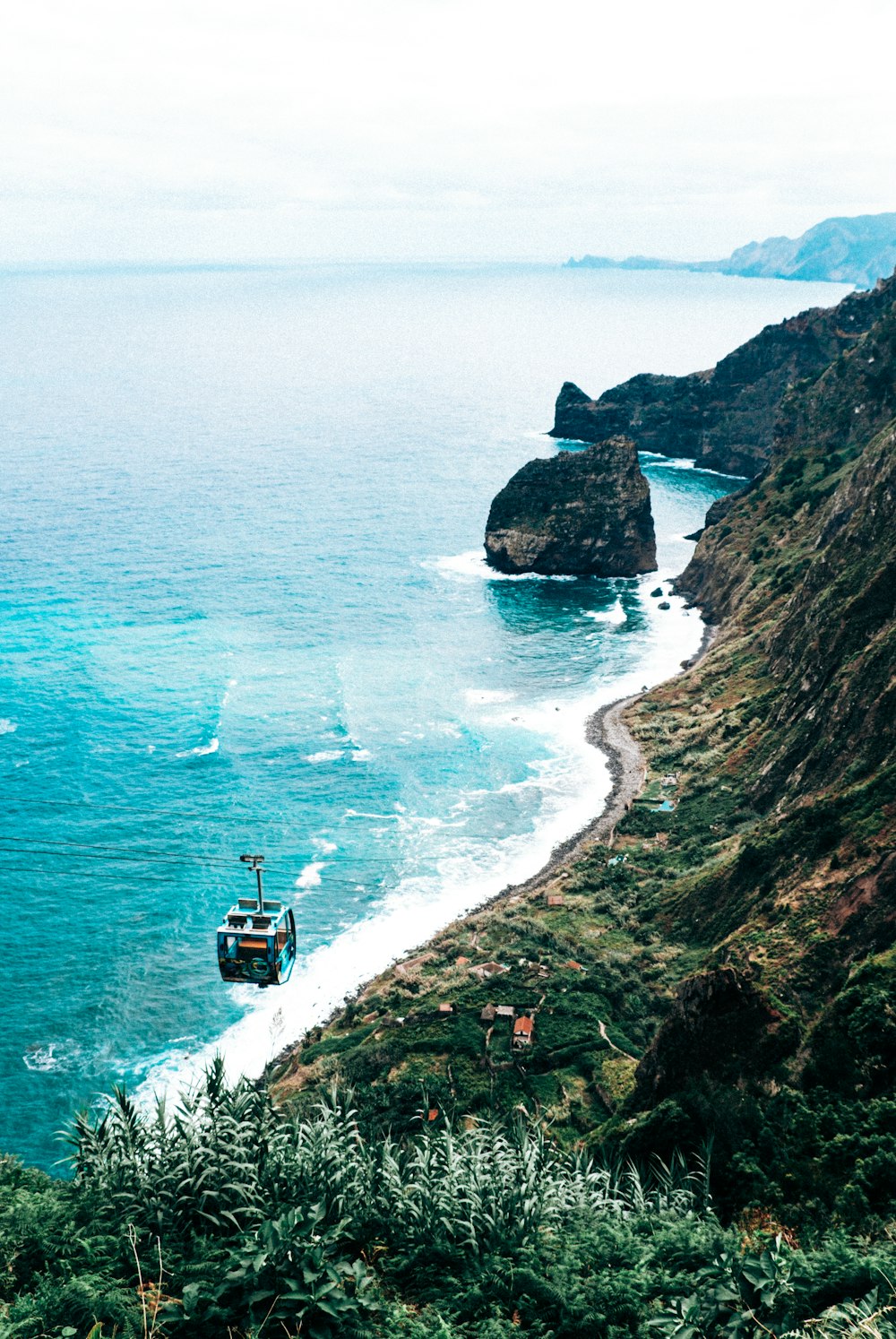 a boat is on the water near a cliff