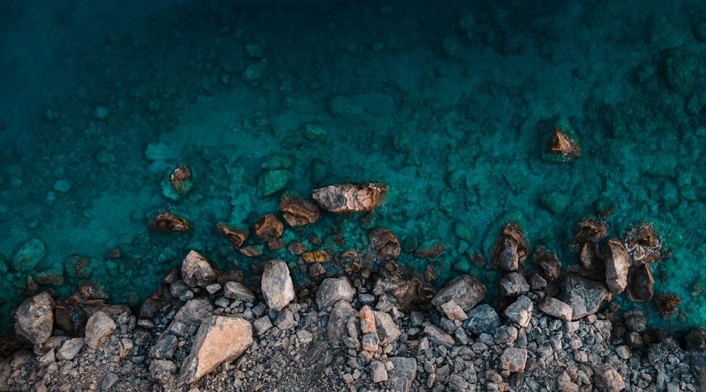 an aerial view of a beach with rocks and water