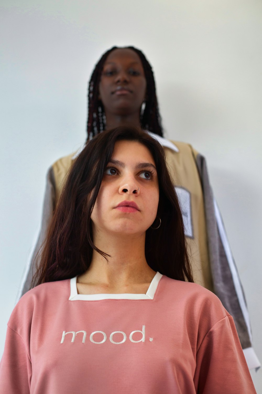 a woman standing next to a woman in a pink shirt