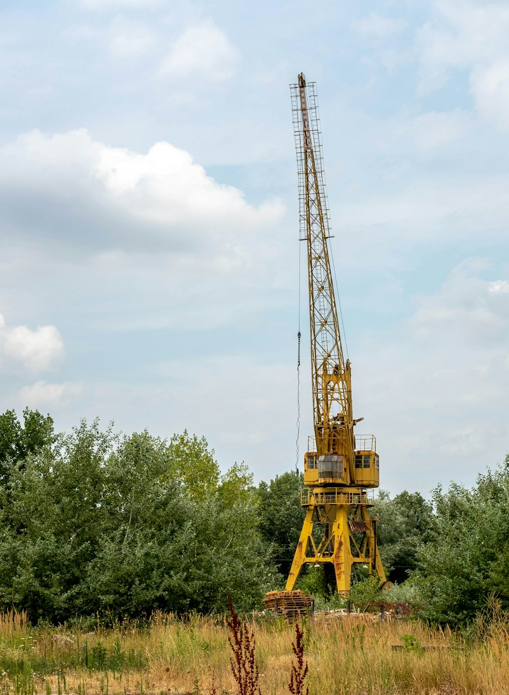 a large yellow crane sitting in a field