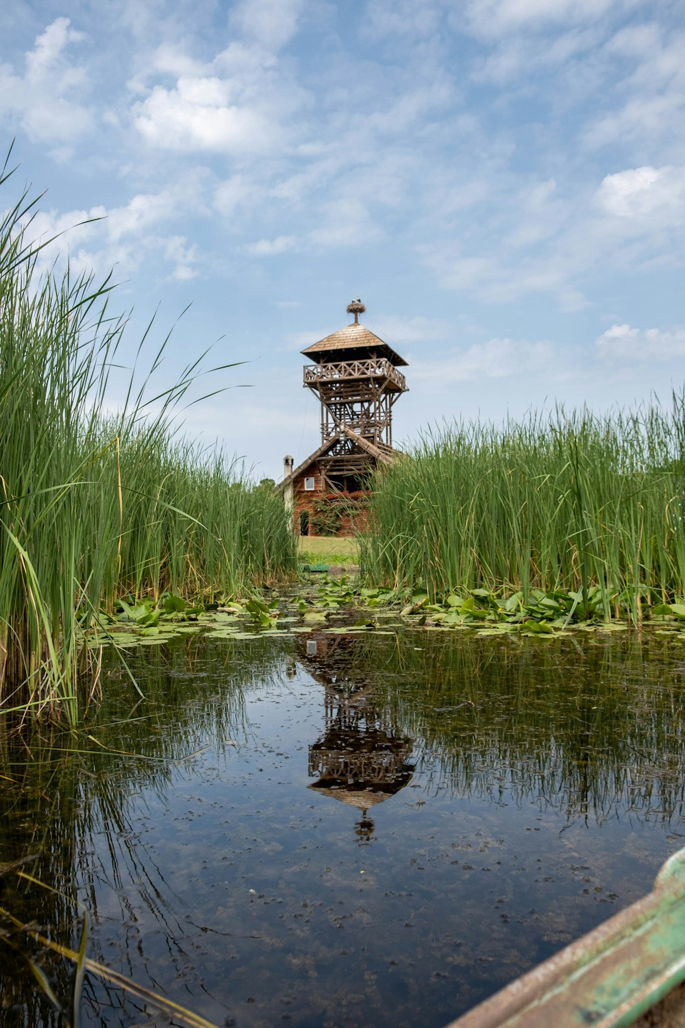 a wooden boat in a body of water with a tower in the background