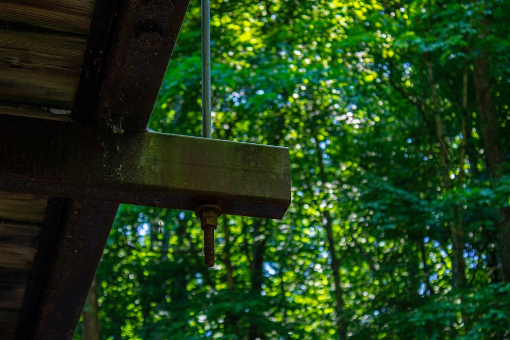 a bird feeder hanging from the side of a wooden structure